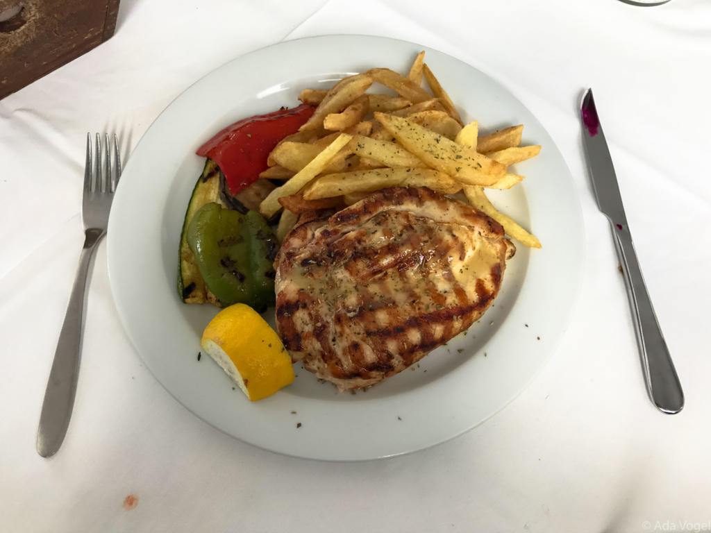Grilled chicken with homemade chips and roasted veg in a beautiful Greek restaurant in Santorini